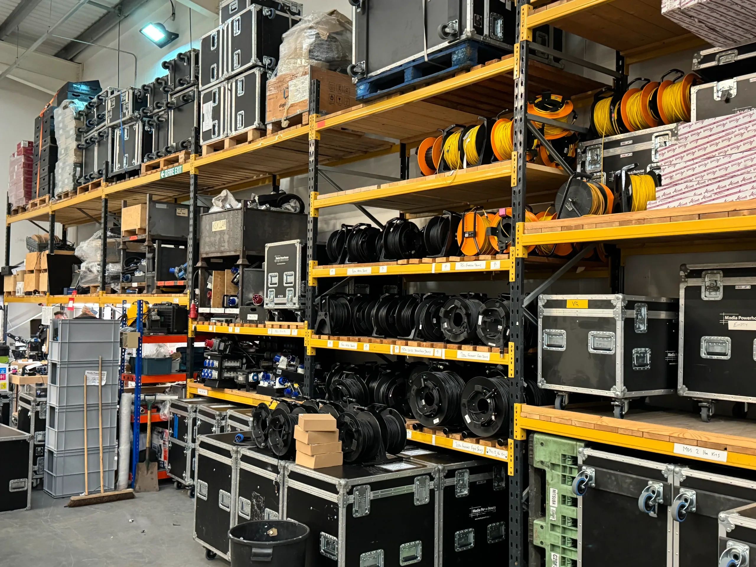 Shelving with cable reels, road cases, and event production accessories.