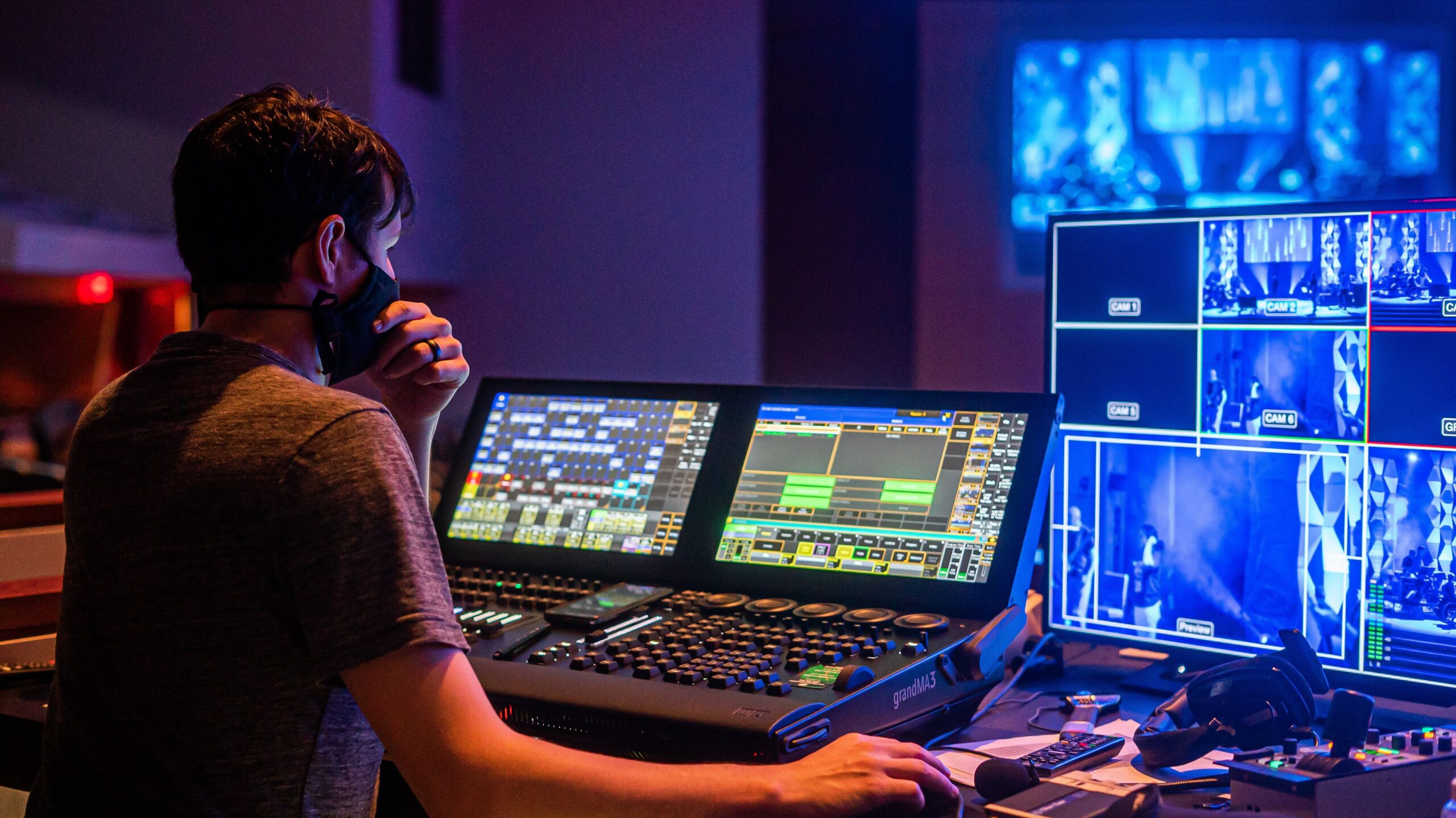 Technician at a production console with video monitors during a live event