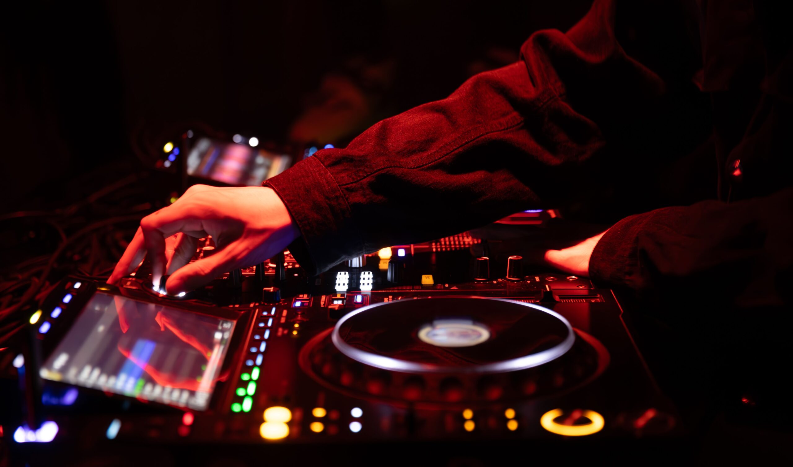 DJ operating audio mixing equipment during an event.